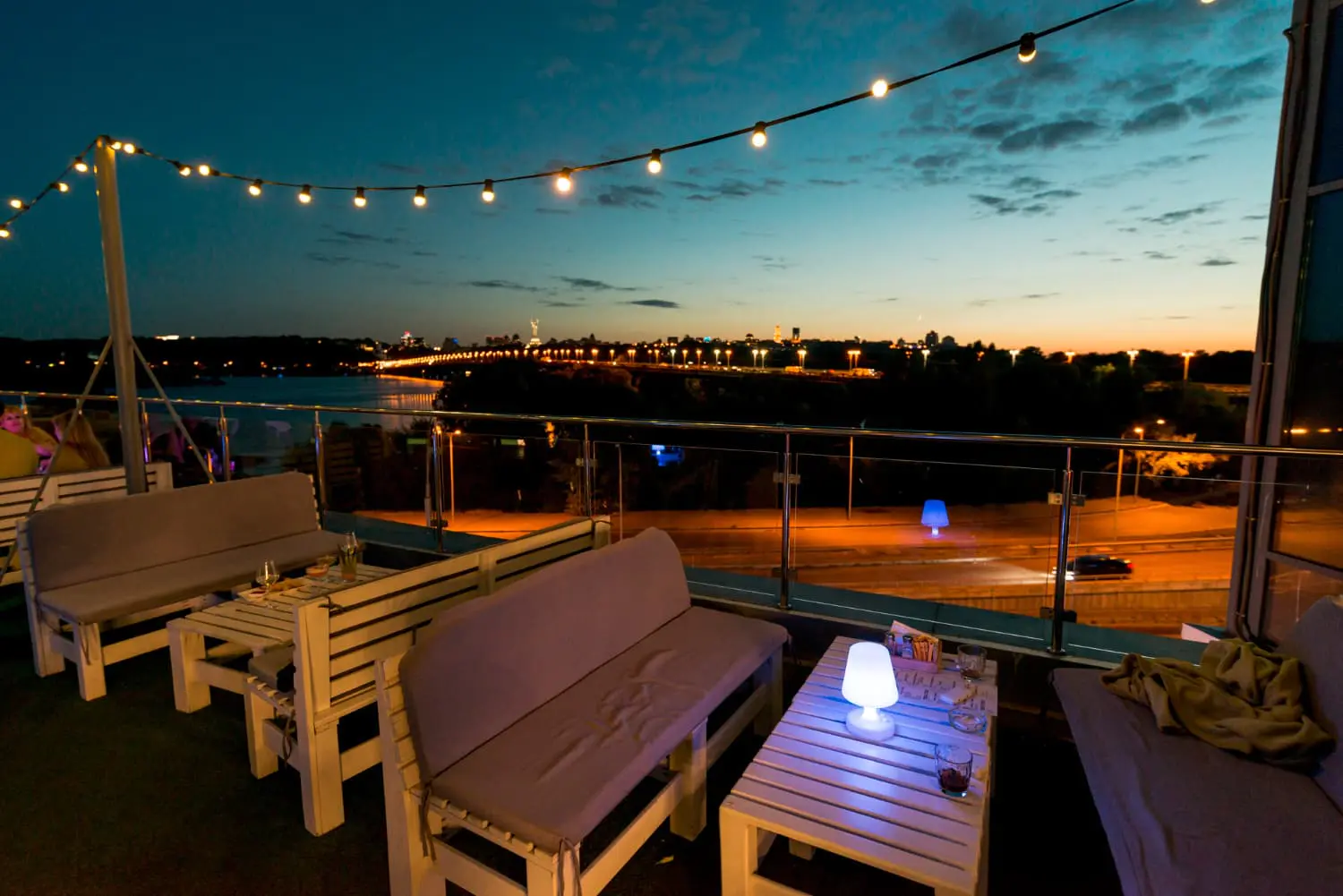 City skyline at night with patio and lights illuminated by dusk to dawn outdoor lighting - What is dusk-to-dawn outdoor lighting? - Vorlane - Vorlane