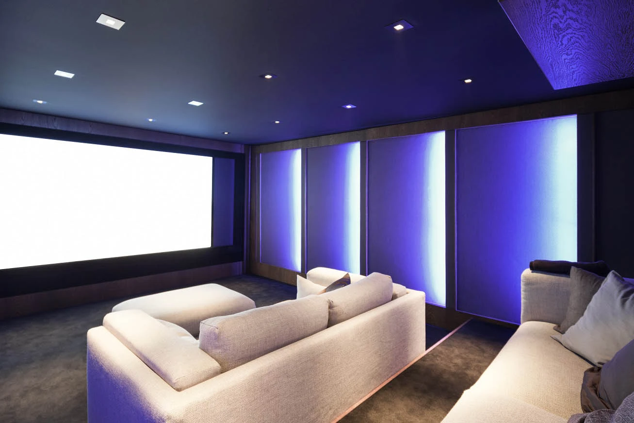 Cozy home theater with couch and projector screen featured in Complete Guide to Home Theatre Lighting - Essential Home Theater Lighting Tips for an Immersive Experience - Vorlane - Vorlane